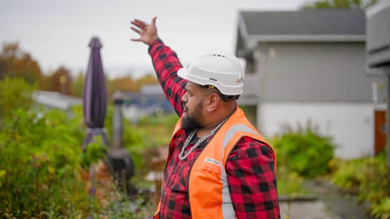Scene fra reklamefilm for PEAB. En PEAB bas signaliserer med armen at de andre skal komme.