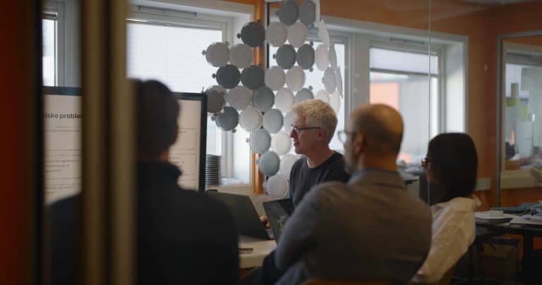 Personer analyserer data på en laptopskjerm